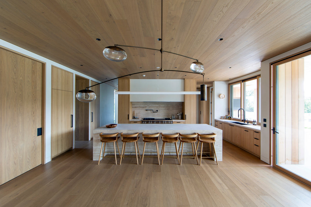 MADERA's smoked European oak cabinetry and ceiling planks create a cohesive, light-filled kitchen with natural warmth throughout.