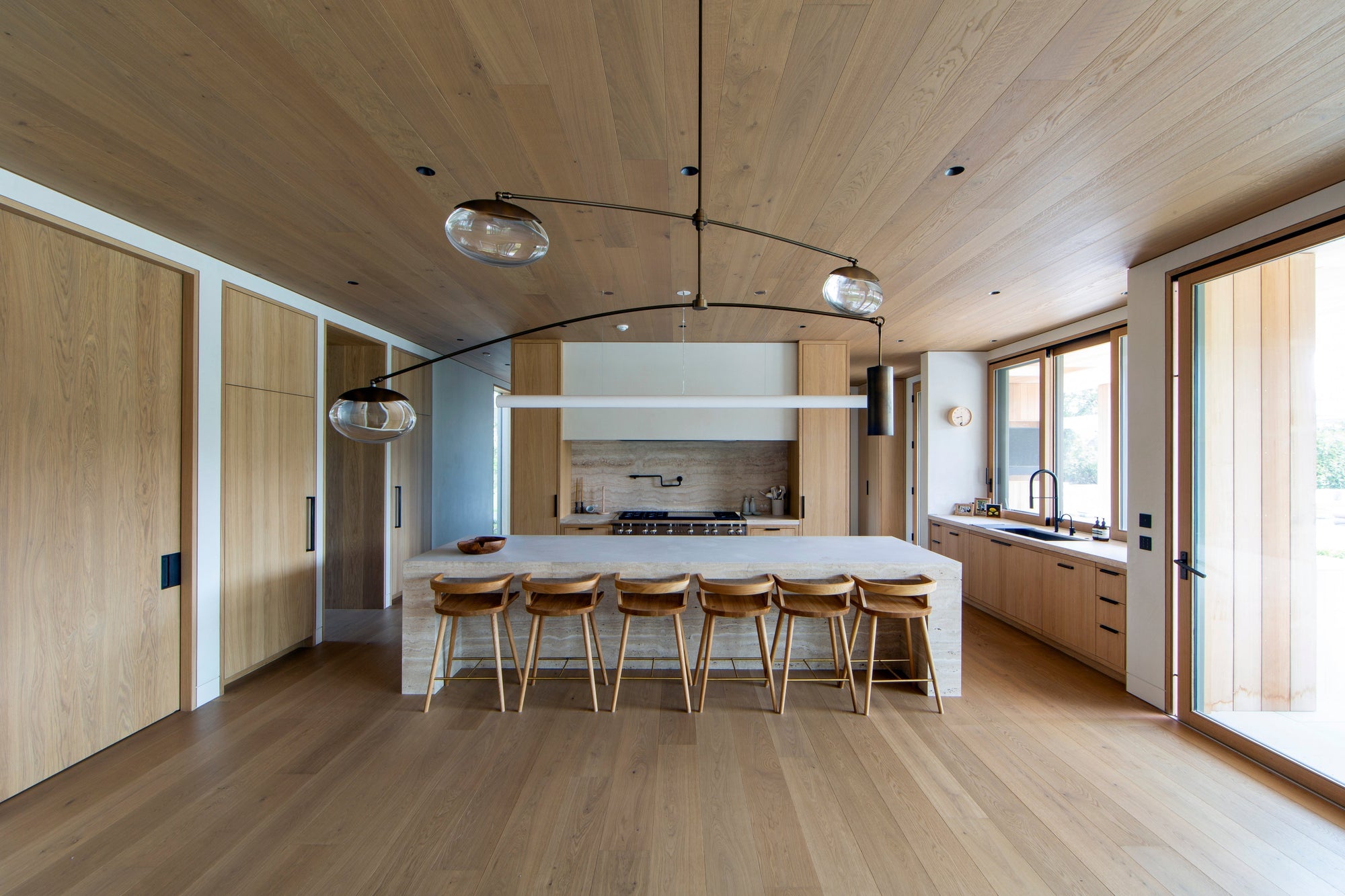 MADERA's smoked European oak cabinetry and ceiling planks create a cohesive, light-filled kitchen with natural warmth throughout.