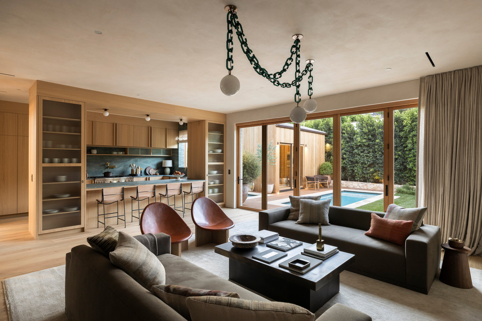 Wide-plank oak flooring and integrated cabinetry by MADERA unite kitchen and living areas in this open-concept design.
