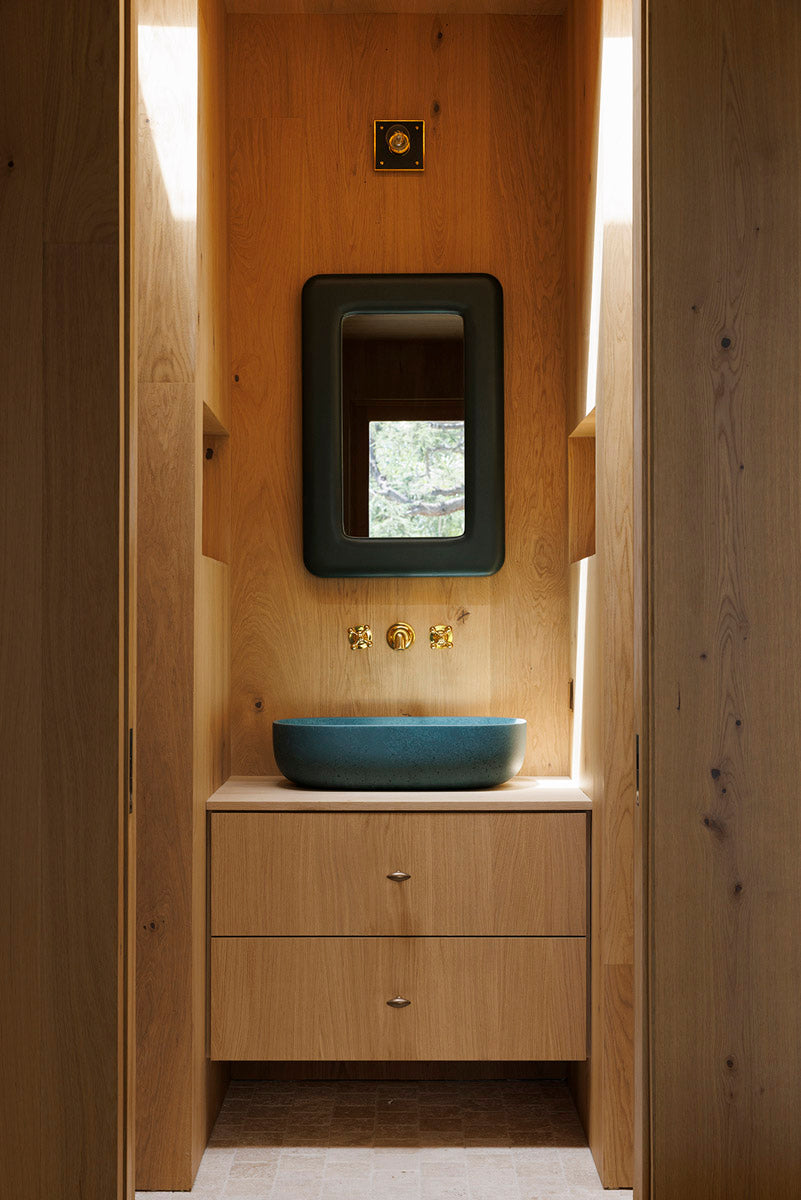 MADERA's complete oak wall cladding and custom vanity transform this powder room into a serene, spa-like retreat.