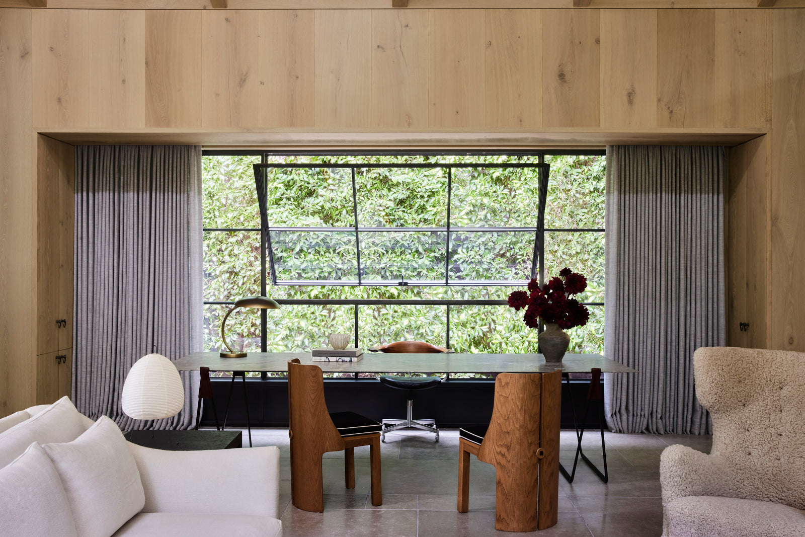 Heart oak flows seamlessly from floor to ceiling and across built-in cabinetry, creating a unified workspace that frames the canyon landscape beyond.