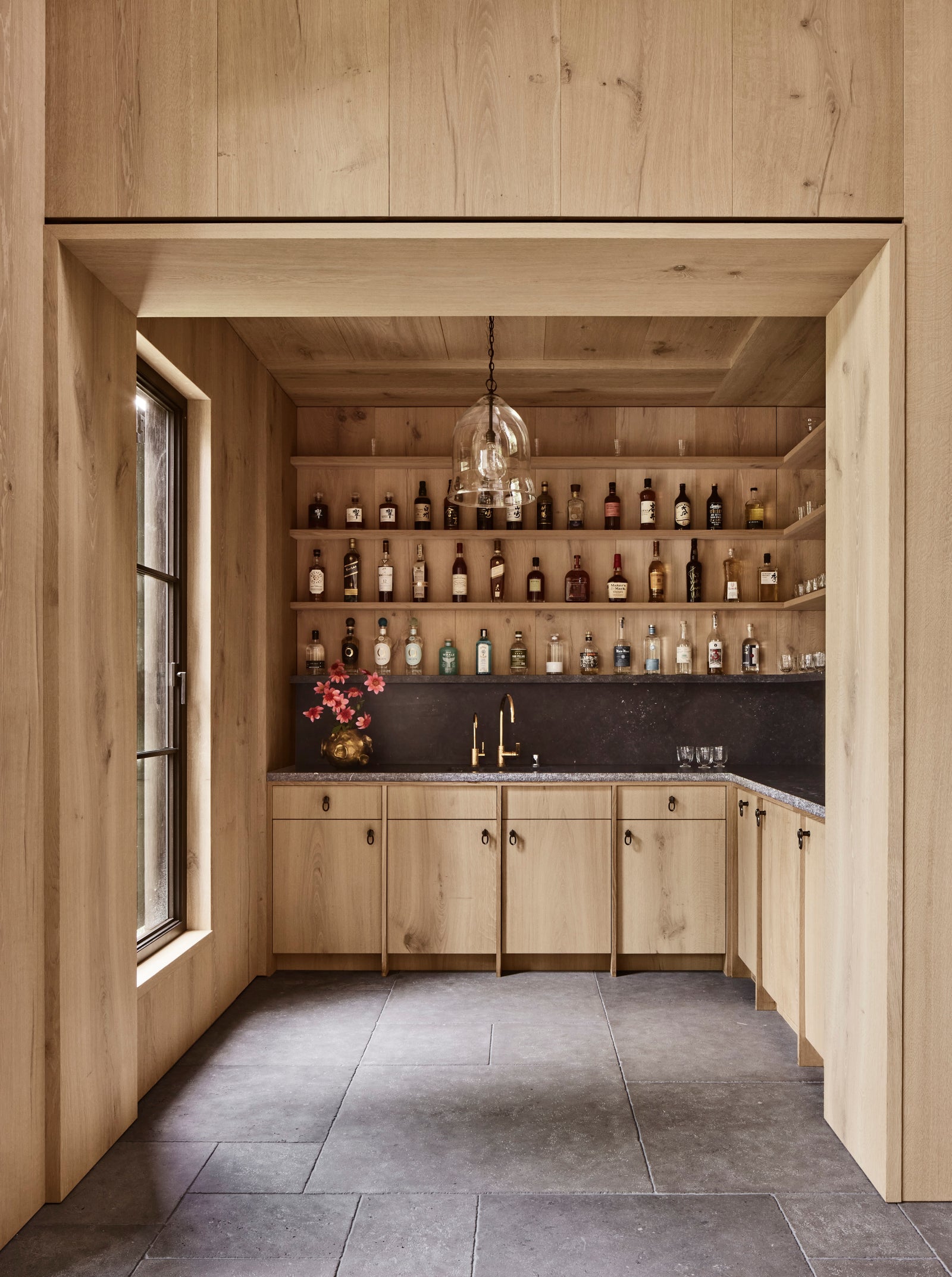 Custom millwork demonstrates precision joinery. Heart oak shelving and cabinetry unite in a single material voice, where every surface speaks to the whole.