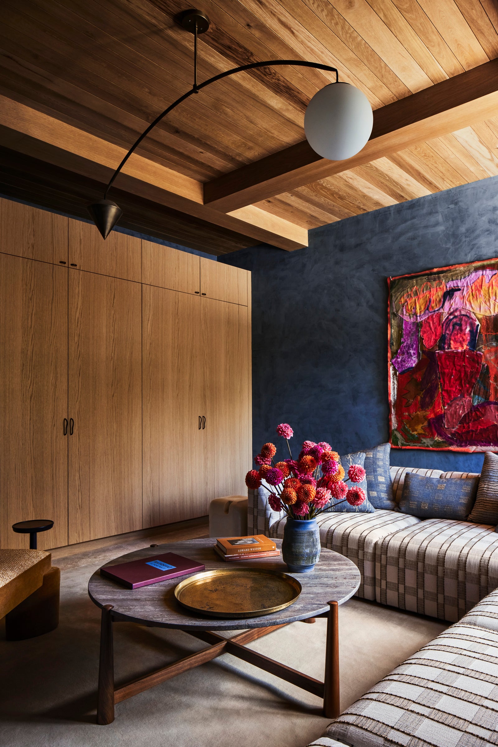Exposed oak beams and custom cabinetry by MADERA create rich textural contrast in this boldly designed living space.