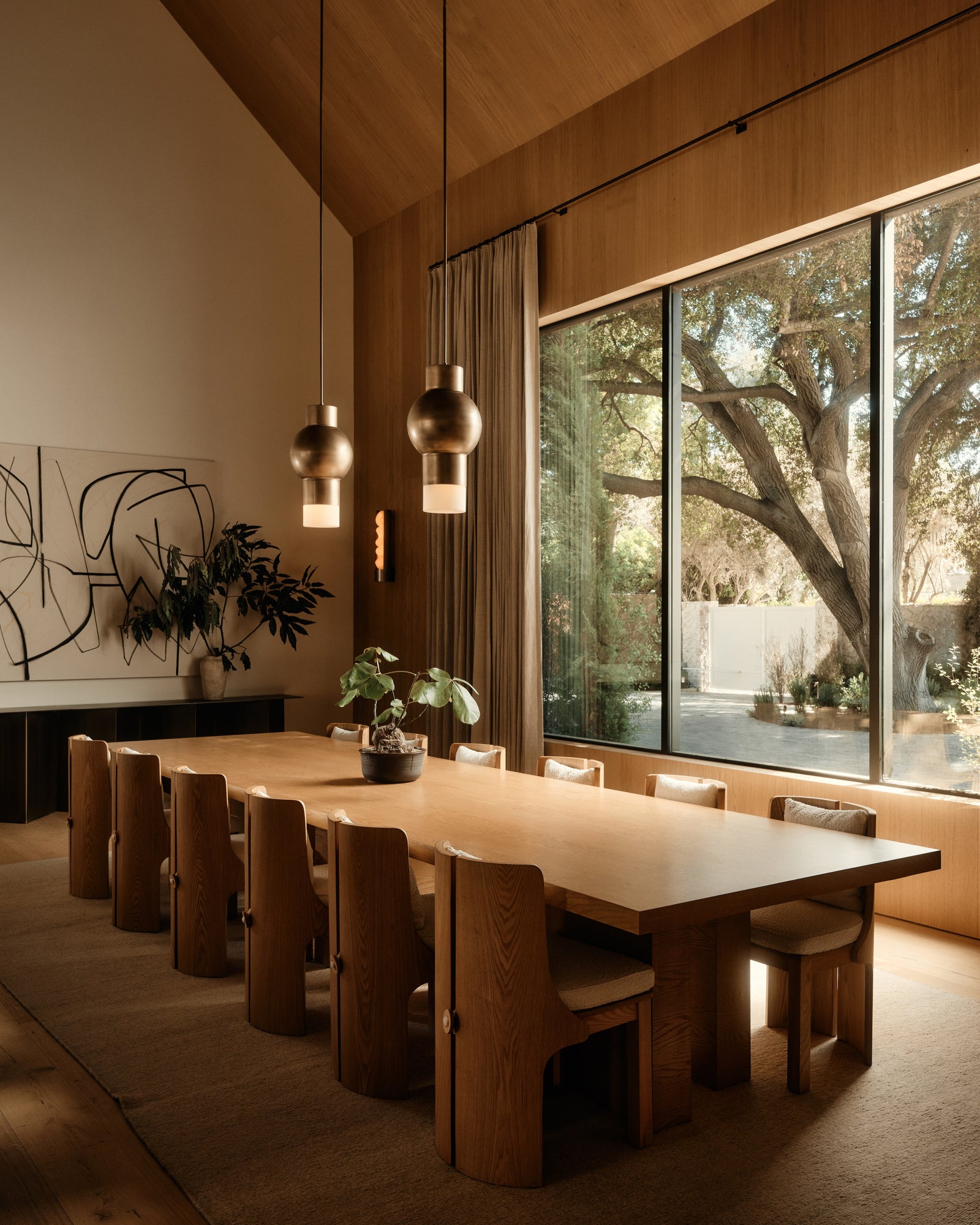 MADERA's oak surfaces unite this dining space, from the cathedral ceiling to the custom table and sculptural chairs.