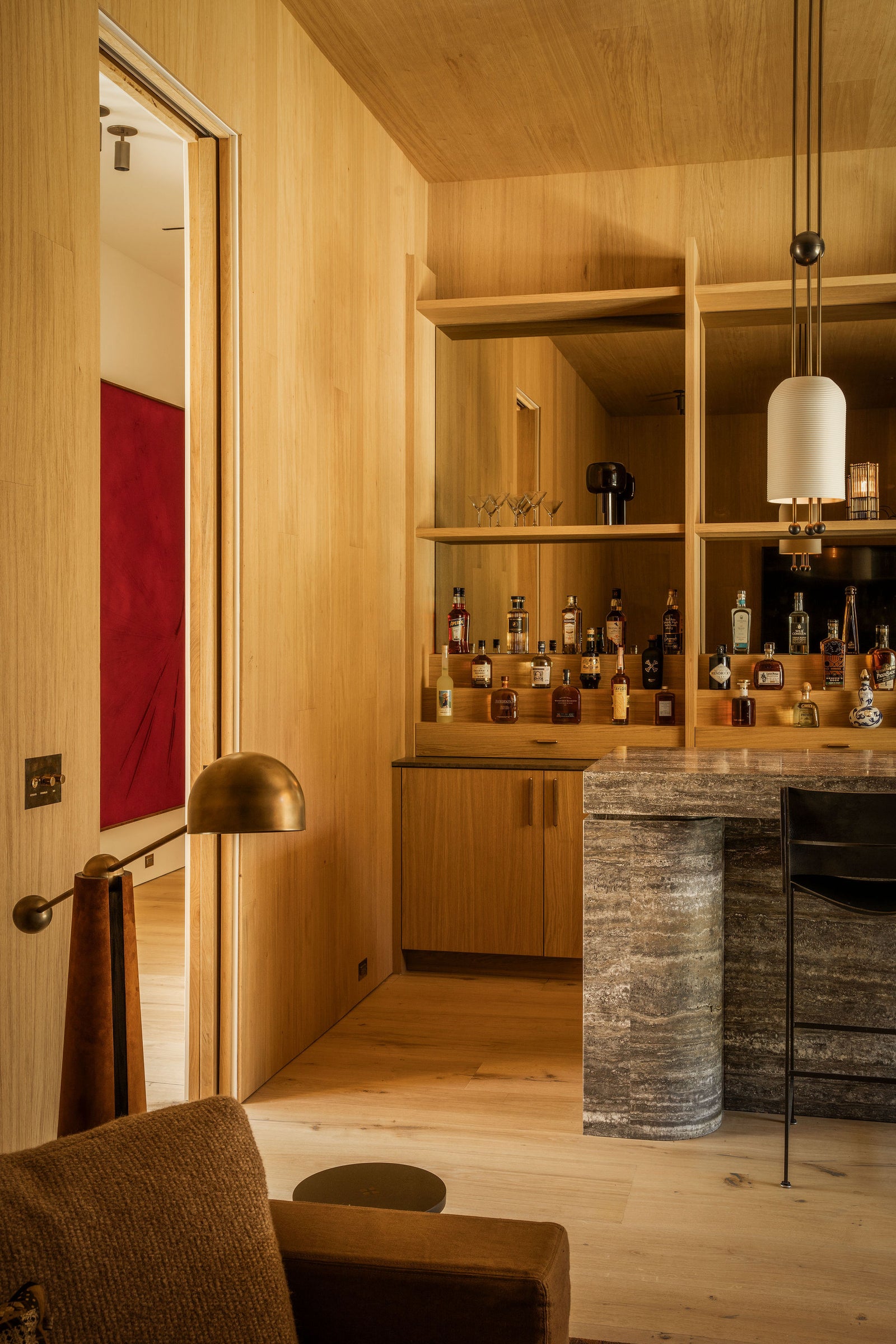 MADERA's floor-to-ceiling oak paneling creates a seamless backdrop for this elegant bar area with integrated display shelving.